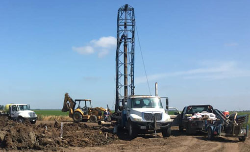Mid-Valley Drilling Rig drilling a for a well in a field.